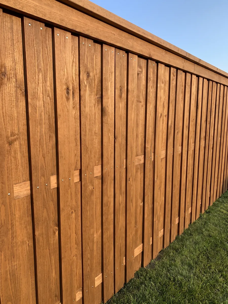 The face of a new stained cedar privacy fence