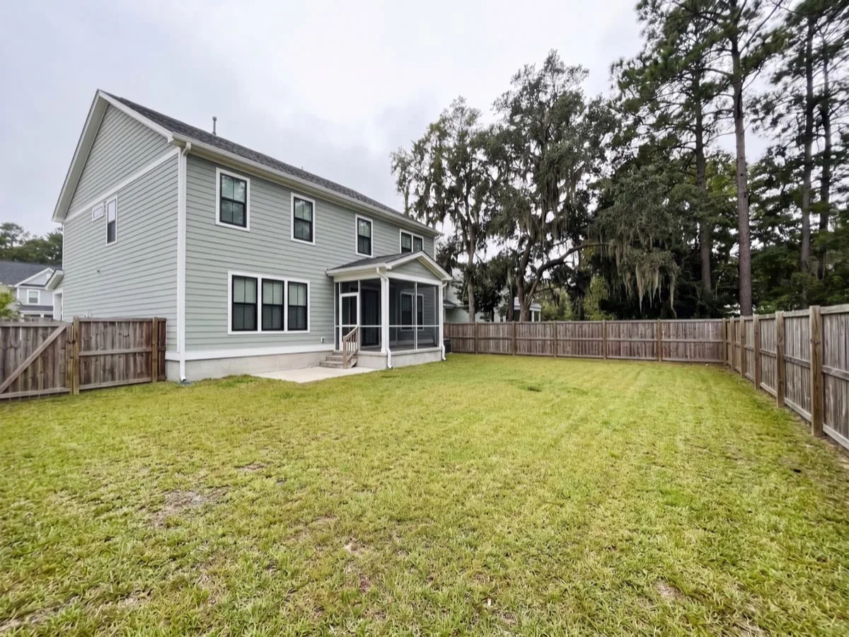 Before: An empty flat backyard with nothing in it but grass and a plain fence