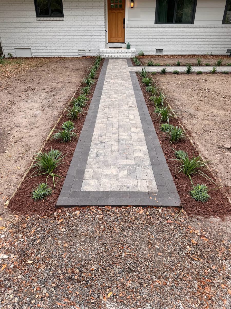 Paver front walk with a charcoal border course and a pale field, with new planted and mulched beds on both sides, in Summerville